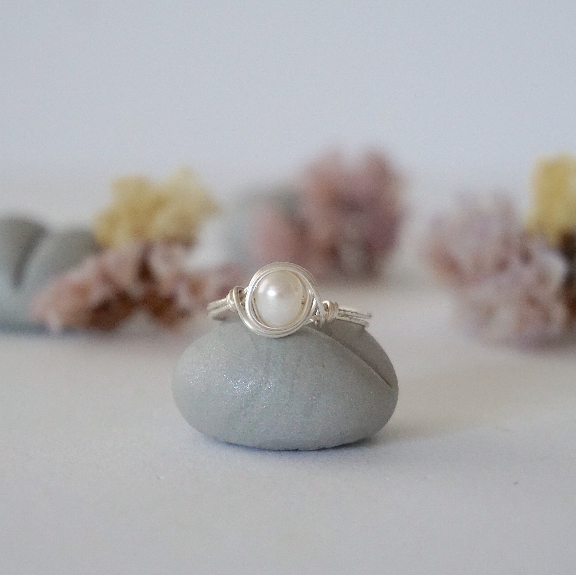 Front view of a minimalist pearl wire wrapped ring featuring a natural freshwater pearl