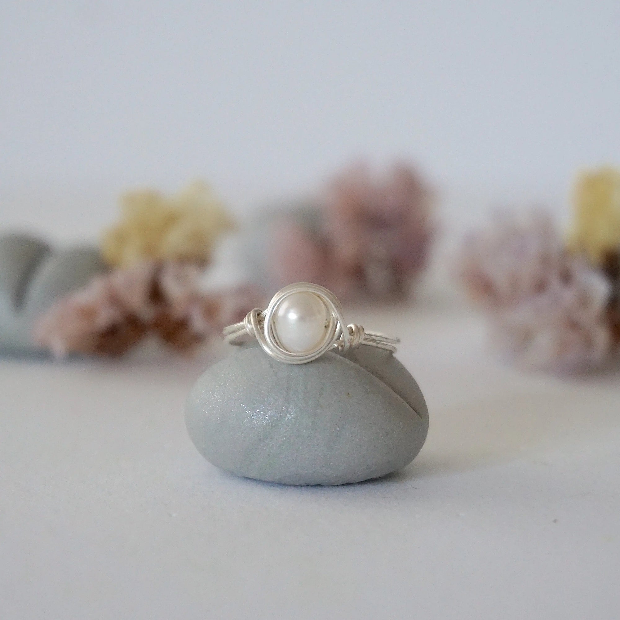 Front view of a minimalist pearl wire wrapped ring featuring a natural freshwater pearl