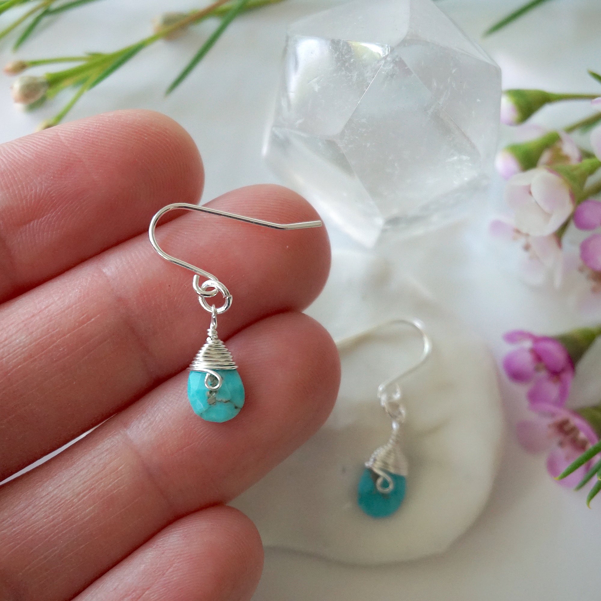 Sterling silver turquoise dangle earrings size reference hand model showing 1.5 inch drop length wire wrapped natural crystal