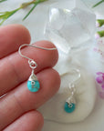 Sterling silver turquoise dangle earrings size reference hand model showing 1.5 inch drop length wire wrapped natural crystal