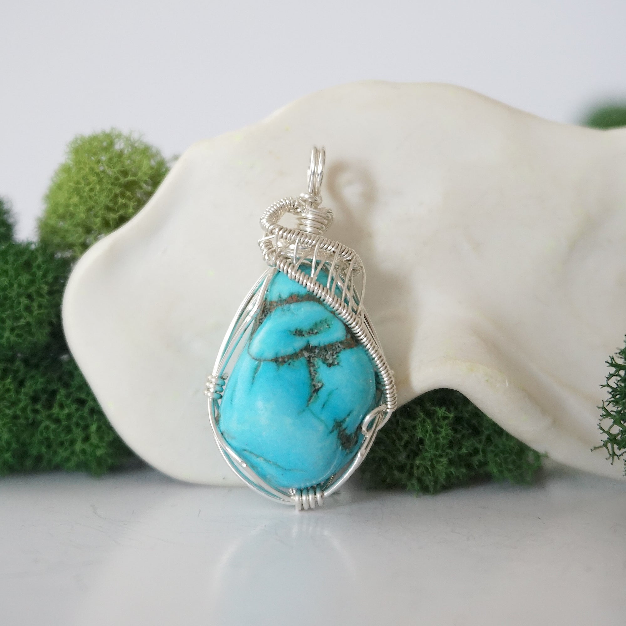 Front view of 925 sterling silver raw turquoise pendant showing detailed wire wrapping, handmade women's crystal jewelry
