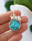 Turquoise and freshwater pearl pendant necklace in hand for size reference, silver wire wrapped, handcrafted gemstone jewelry