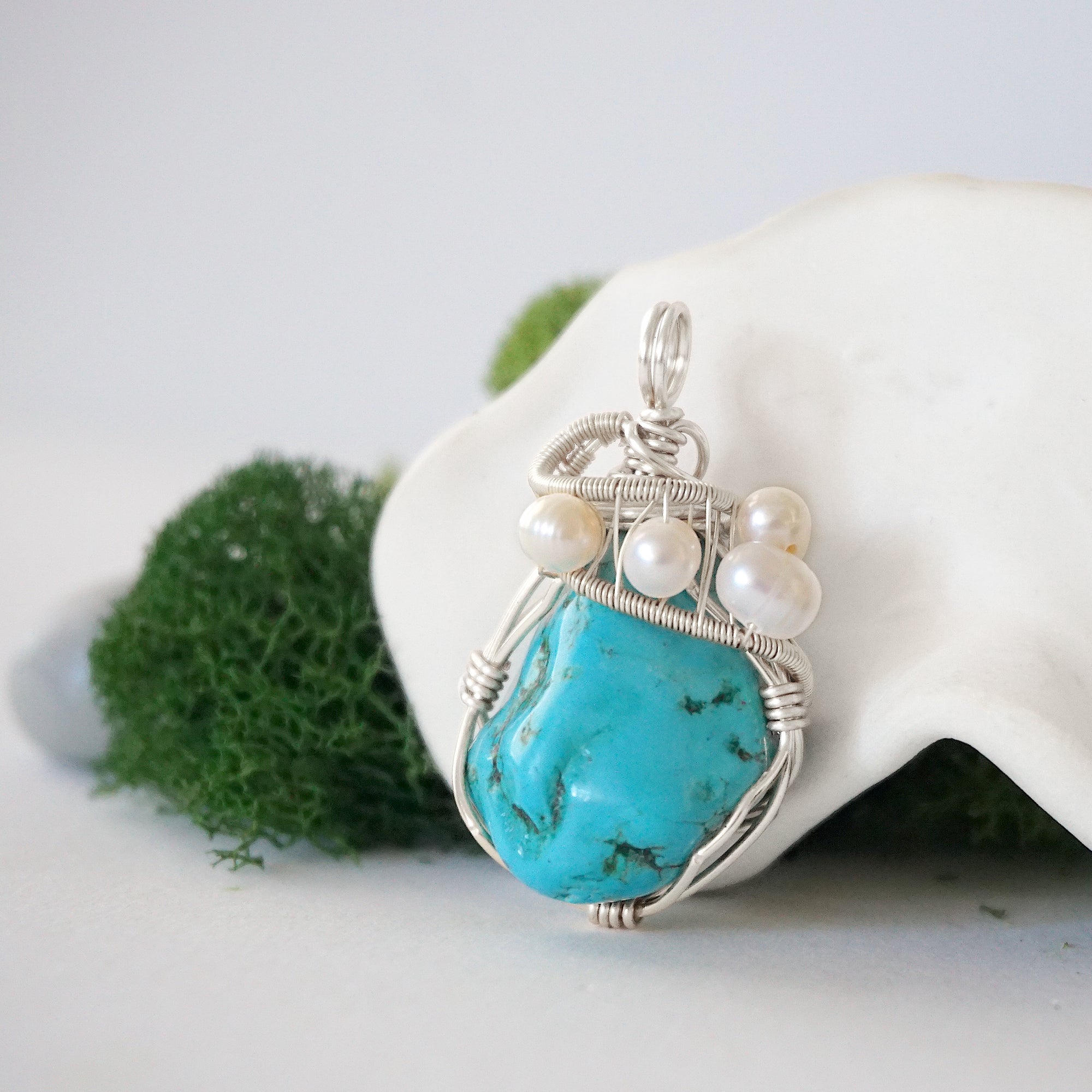 Side angle of handmade turquoise and freshwater pearl pendant necklace, silver wire wrapped jewelry