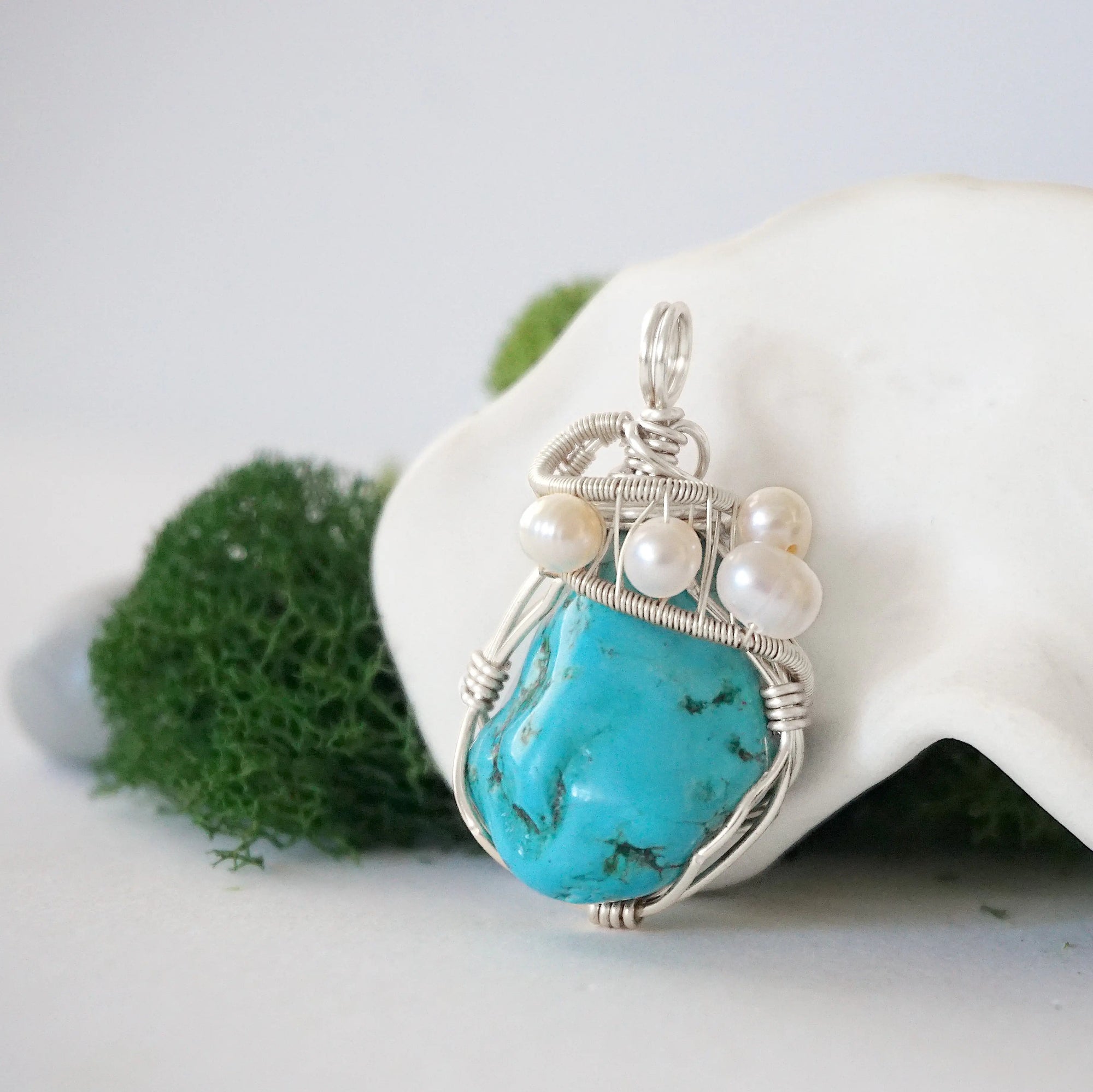 Side angle of handmade turquoise and freshwater pearl pendant necklace, silver wire wrapped jewelry