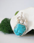 Side angle of handmade turquoise and freshwater pearl pendant necklace, silver wire wrapped jewelry