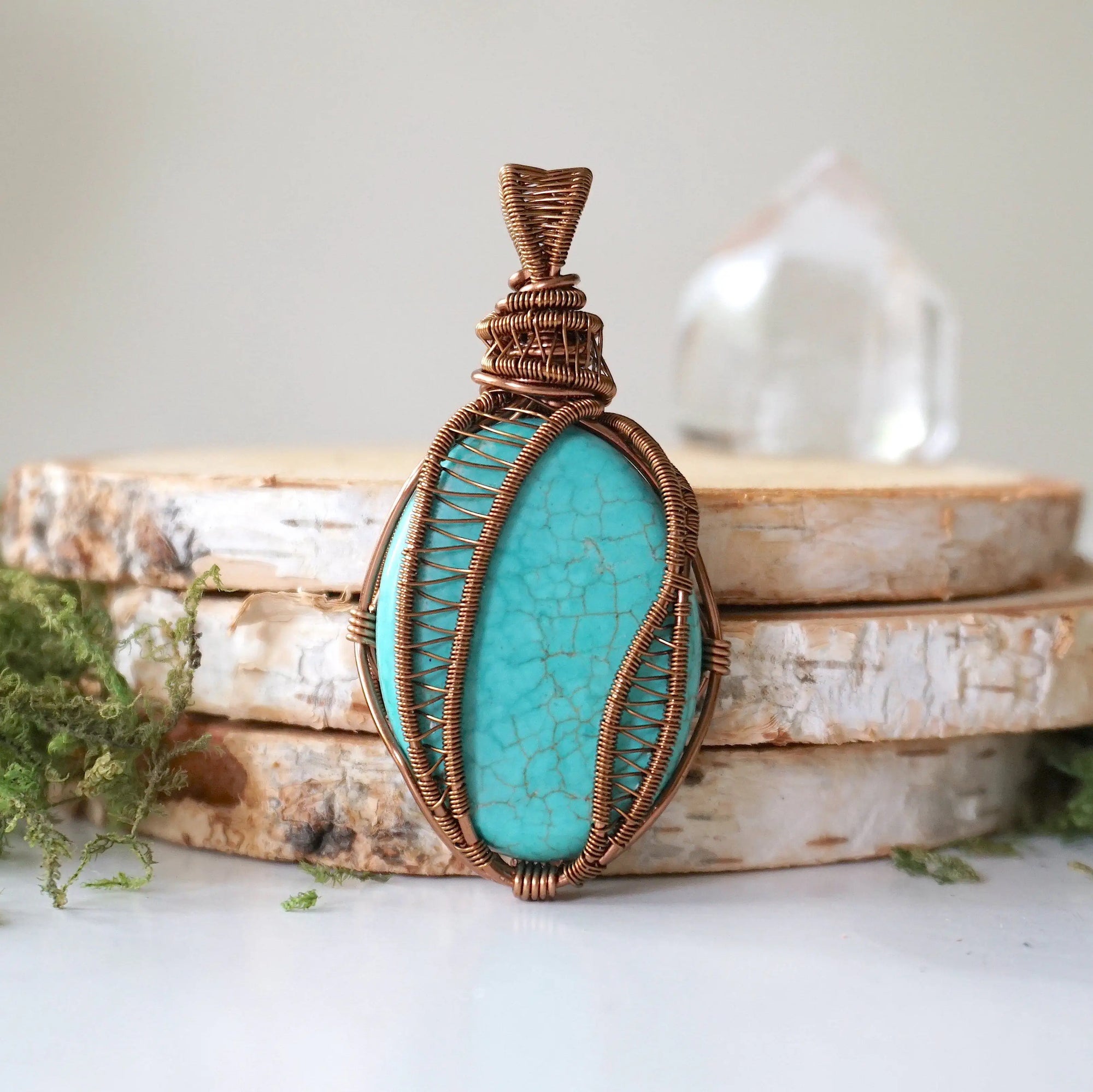 Front detail view of wire wrapped turquoise pendant showing intricate antique bronze copper wire work and polished oval stone