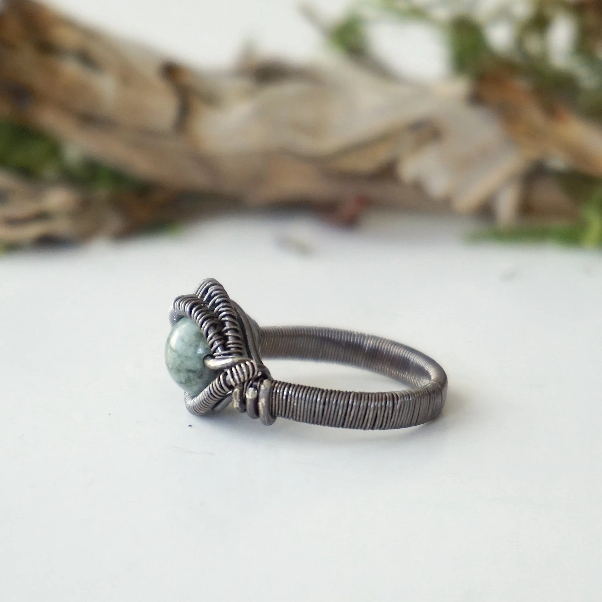 Left side band detail of emerald ring for men in antiqued sterling silver with artisan finish