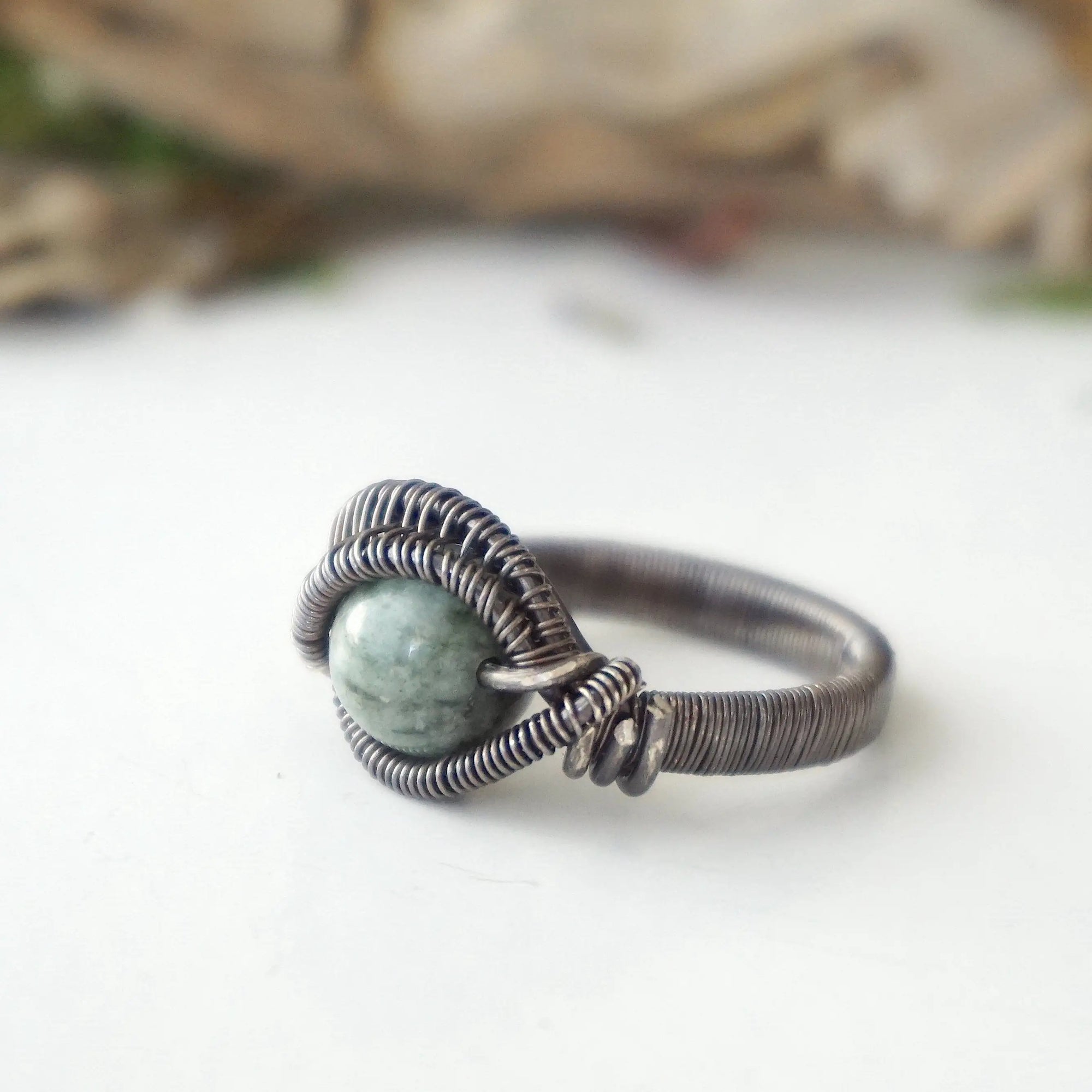 Left side detail of men's emerald ring in antiqued sterling silver with handcrafted wire wrapping artistry