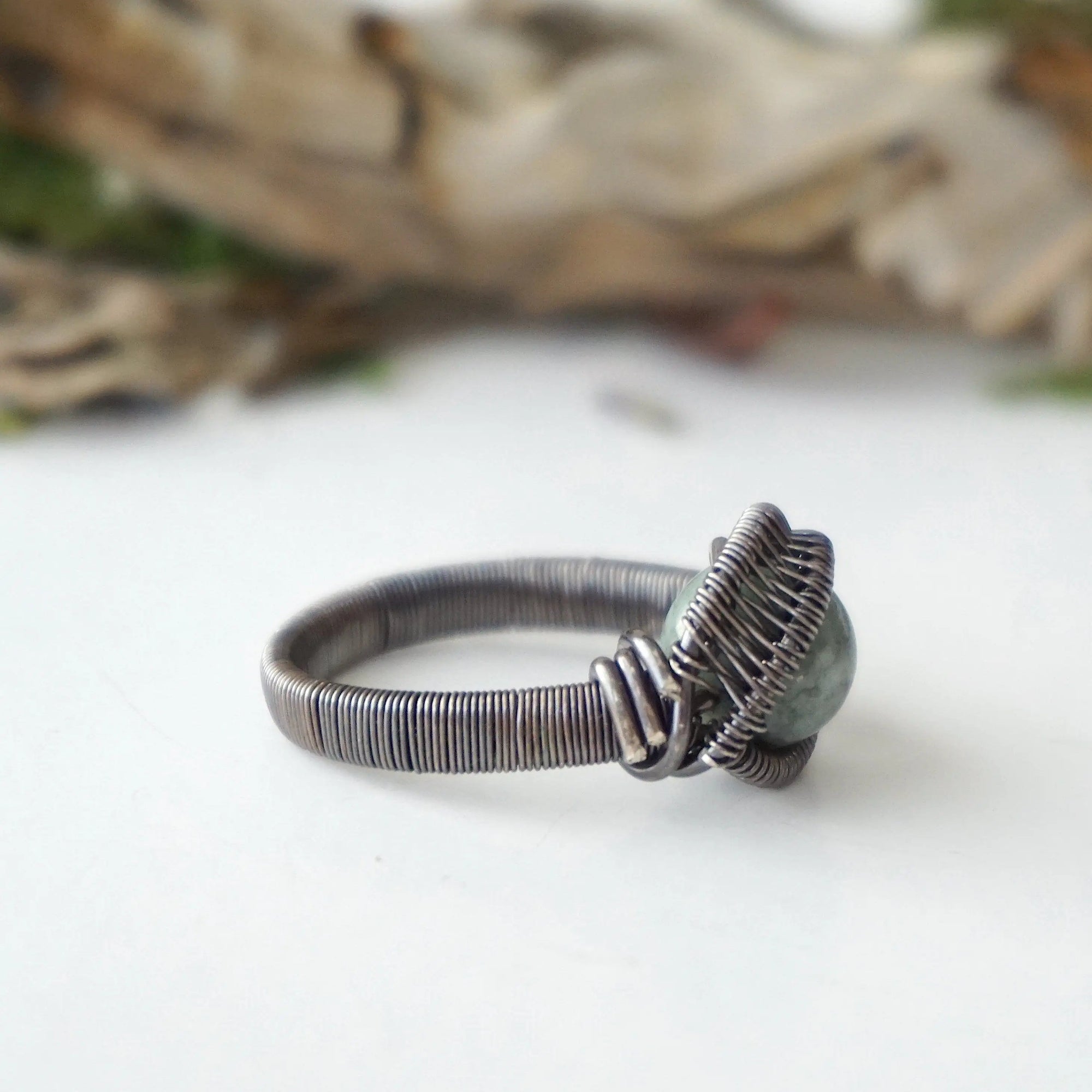 Right side band detail of wire wrapped emerald ring for men in antiqued sterling silver