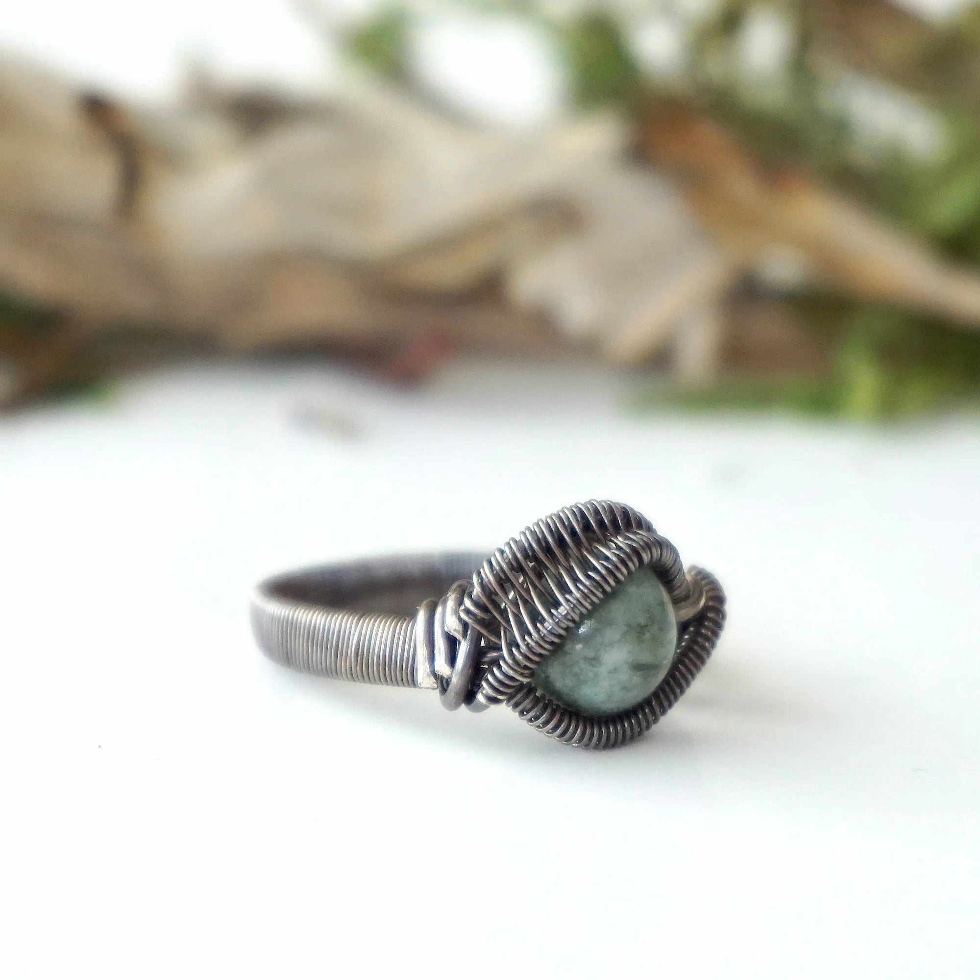 Right side detail of men's emerald ring in antiqued sterling silver showing artisan wire wrapping and emerald bead