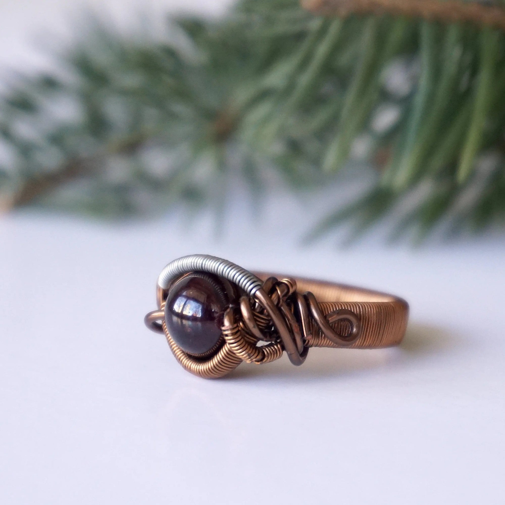 Wire wrapped garnet ring in mixed metal copper with a geometric wire design, shown as the main product image