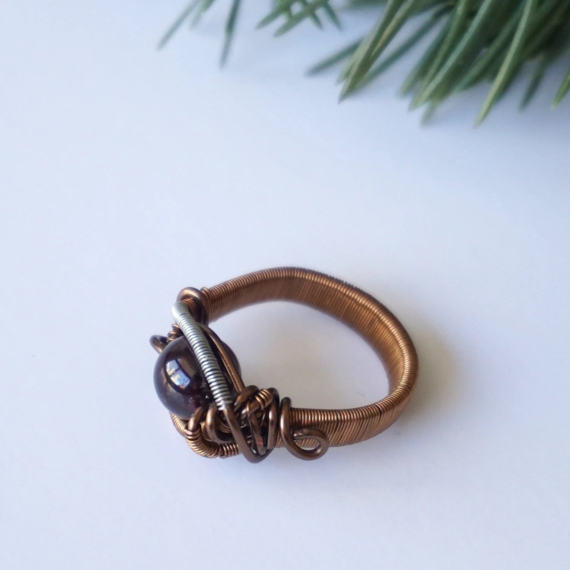 Bird’s-eye view of a wire wrapped garnet ring showing the centered garnet crystal and band width