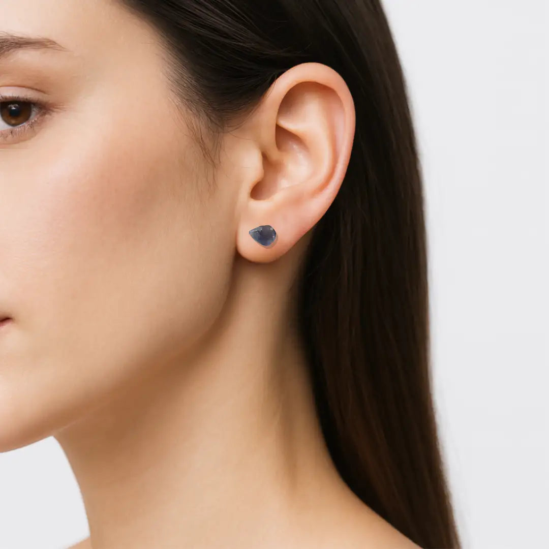 Woman wearing natural raw sapphire stud earrings with 925 sterling silver posts — handcrafted September birthstone jewelry