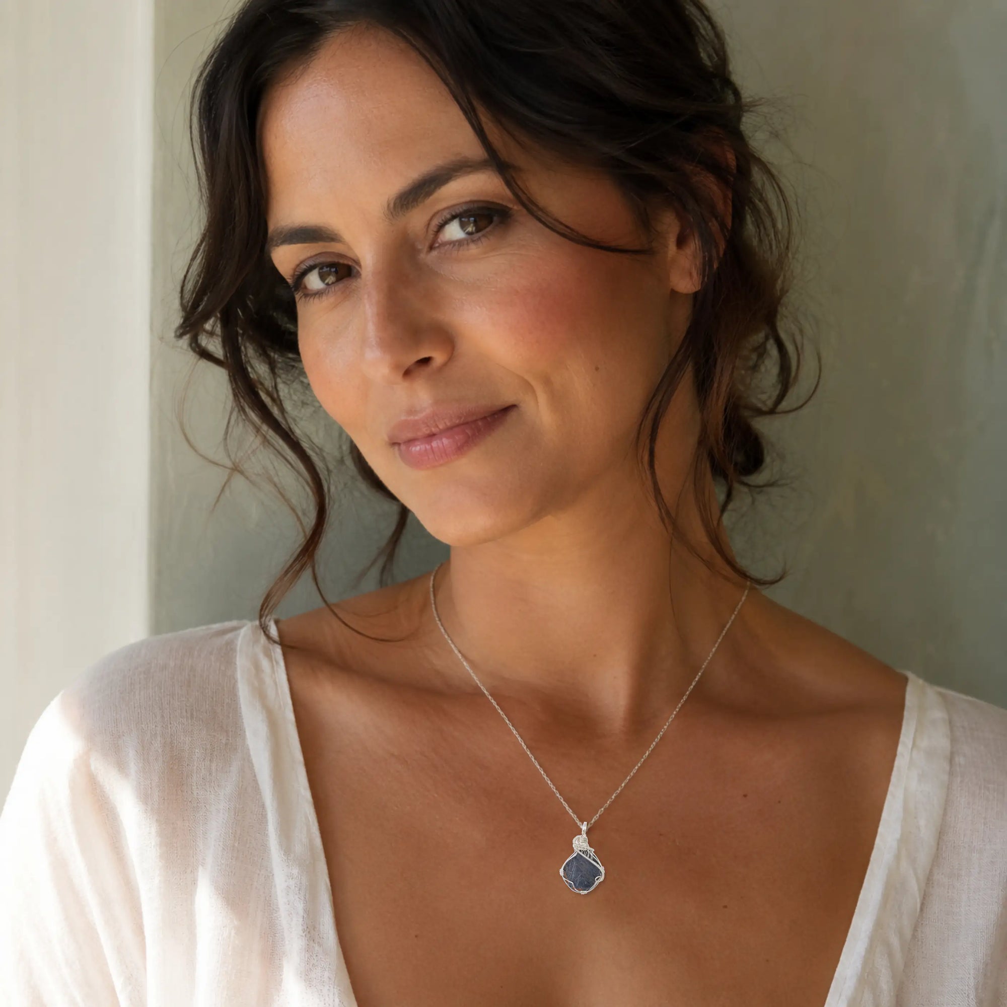 Woman wearing a raw sapphire pendant necklace in 925 sterling silver wire wrap — September birthstone jewelry handcrafted in Toronto by Designs by Nature Gems