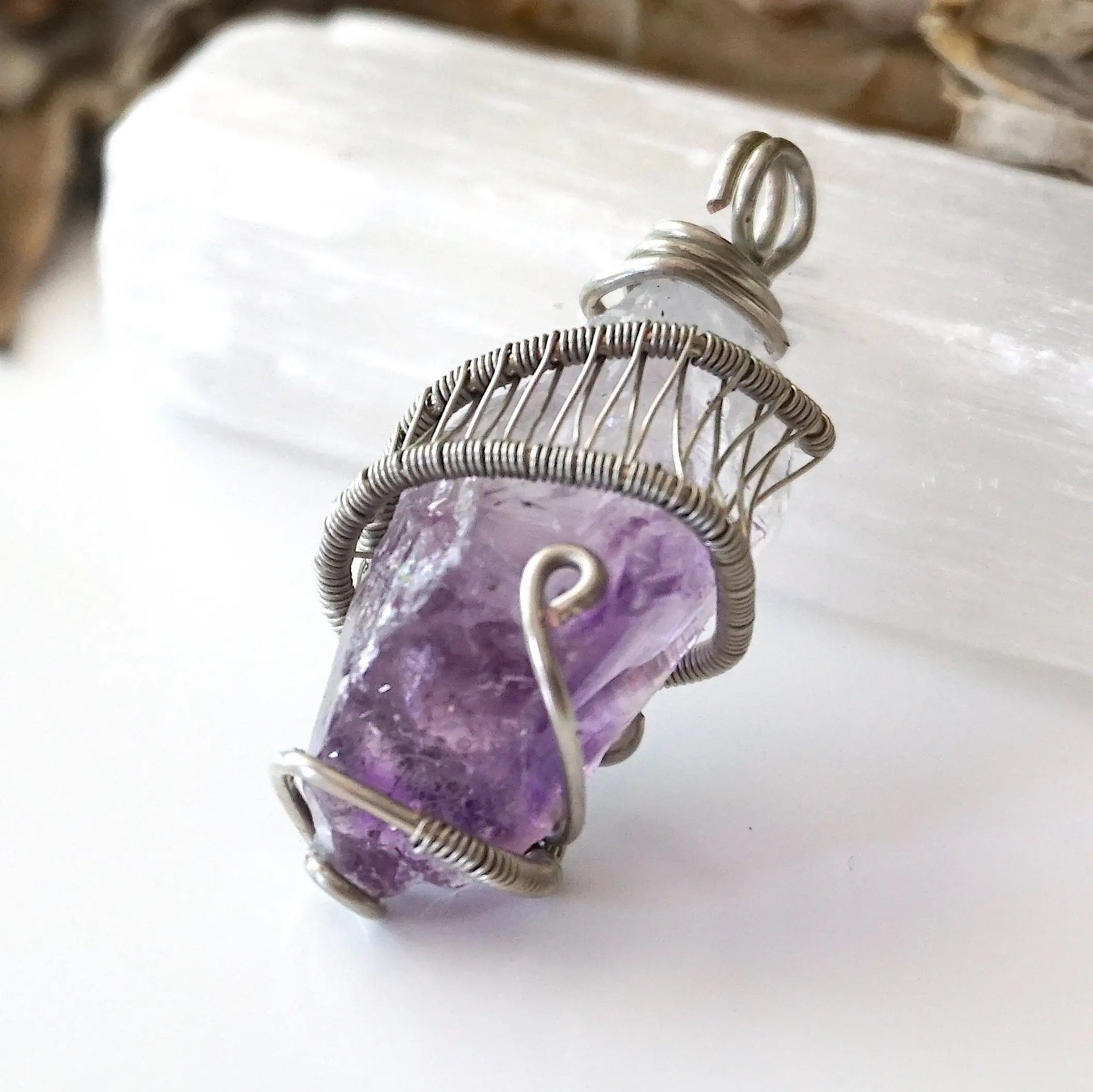 Left side angle of women’s raw amethyst pendant necklace wire wrapped in white gold plated copper