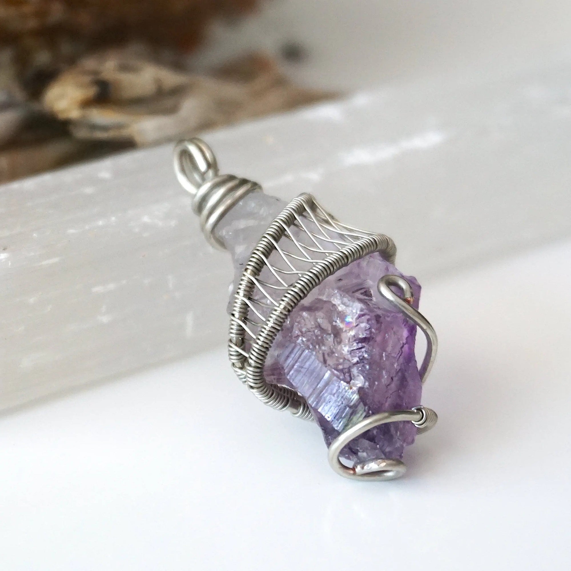 Right side angle of women’s raw amethyst pendant necklace wire wrapped in white gold plated copper