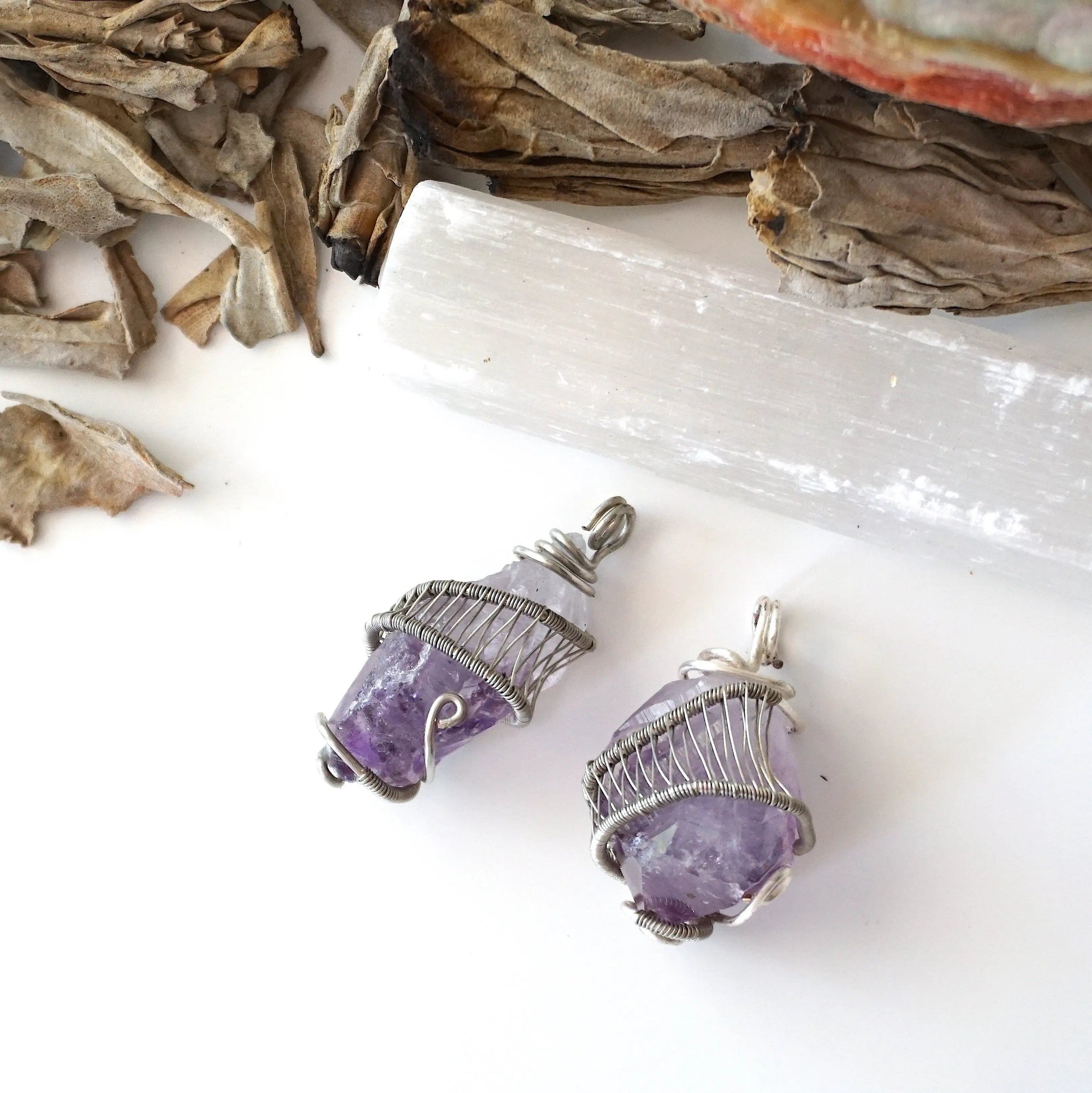 Two women’s raw amethyst pendant necklaces showing natural variation in amethyst color, shape, and size