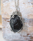 Back angle view of raw black tourmaline necklace for men – showcases wire wrapping and natural stone matrix.