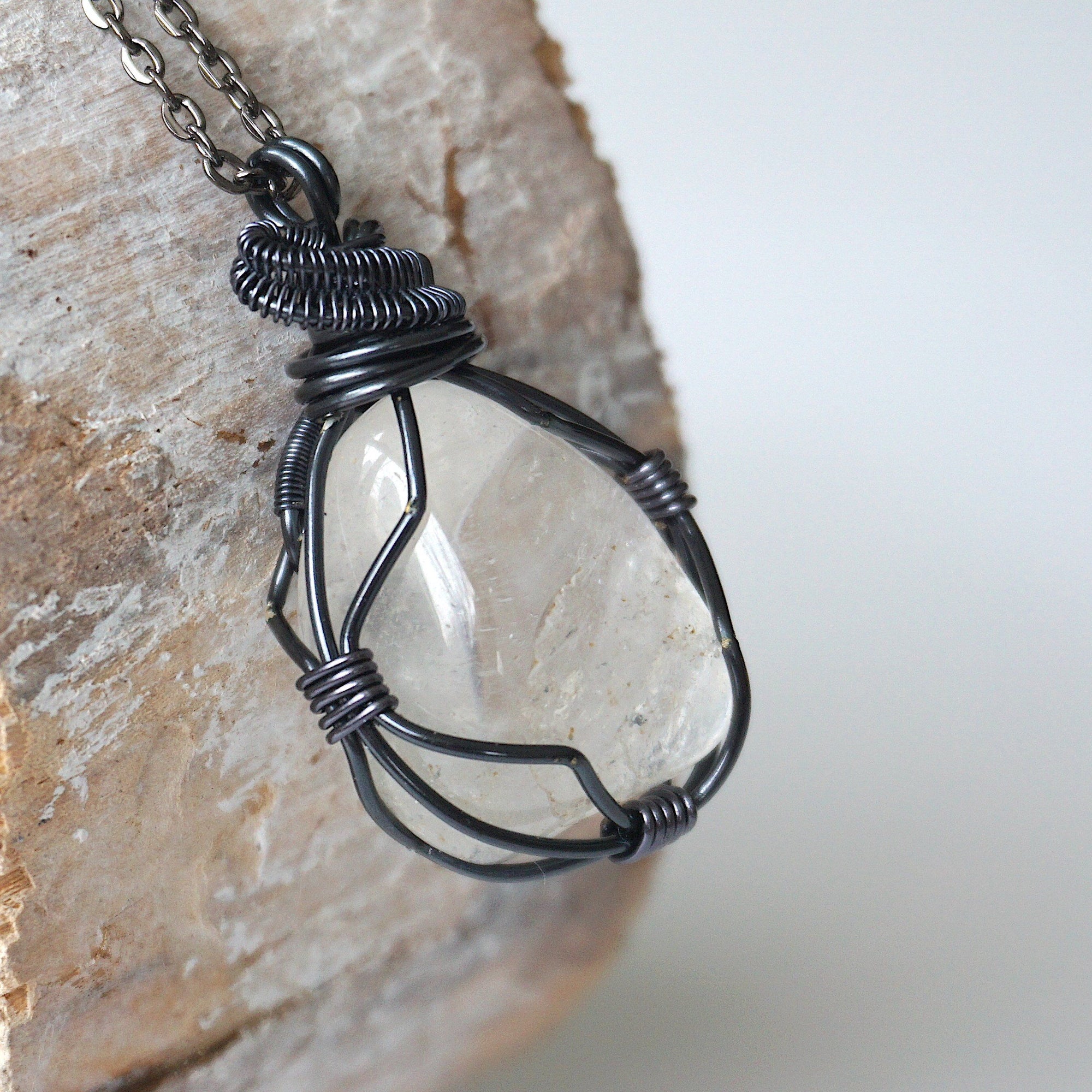 Right angle close-up of clear quartz pendant for men – showcasing artisan wire wrapped gunmetal copper, natural crystal.