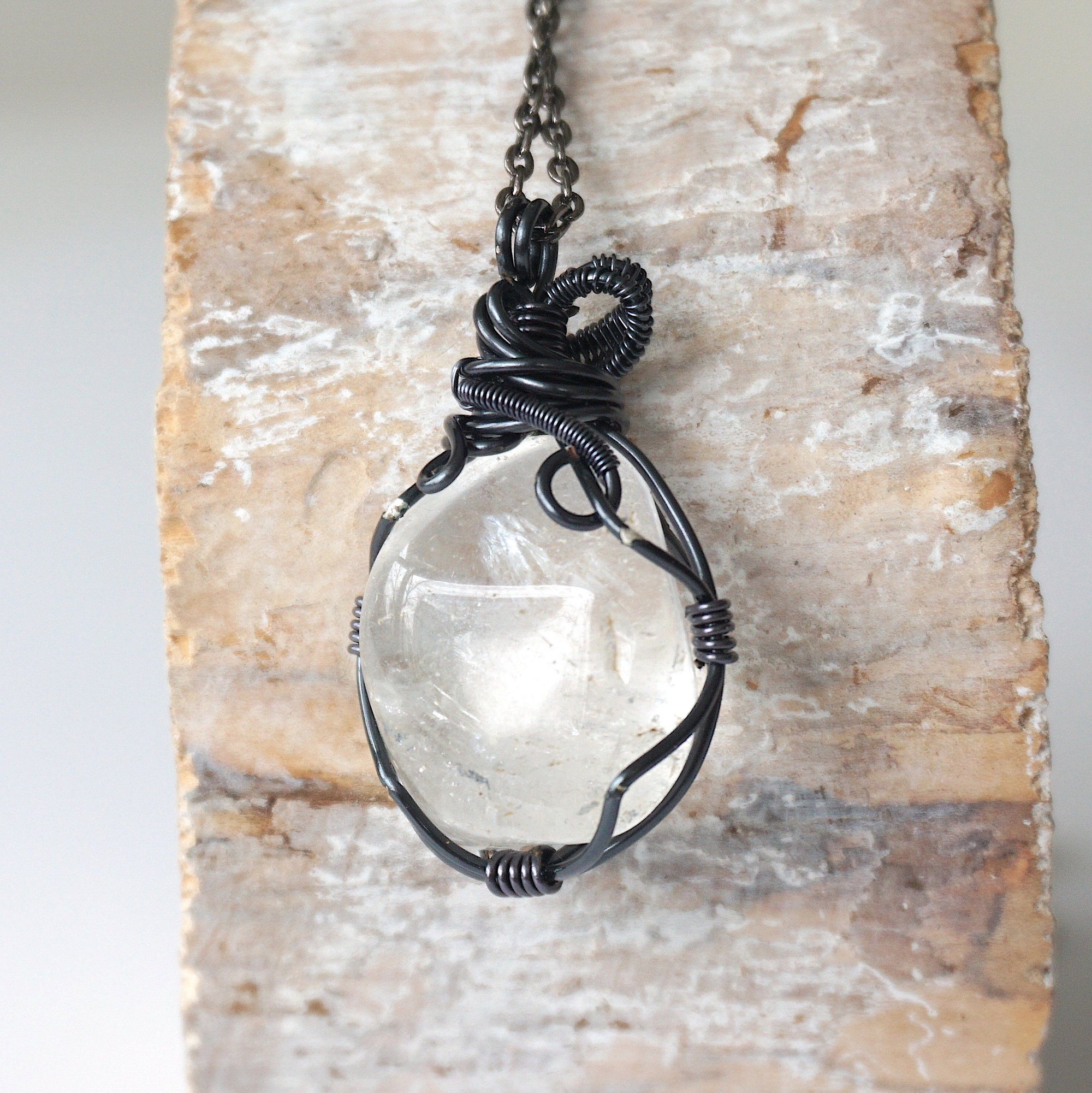 Back view of handcrafted clear quartz pendant for men – natural stone and detailed wire wrapping, April birthstone.
