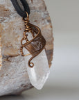 Right angle close-up of clear quartz point necklace for men – detailed antique bronze copper wire wrapping, natural quartz crystal, black leather cord.