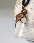Left angle close-up of clear quartz point necklace for men – highlighting unique wire-wrapped artistry, clear quartz, black leather cord.