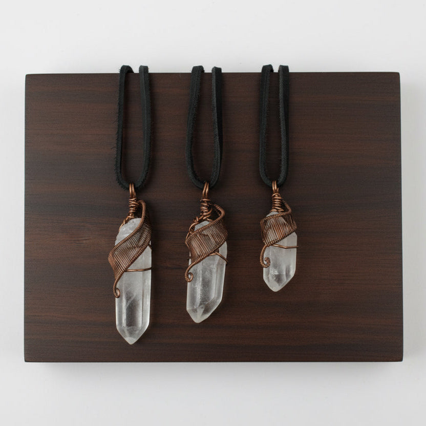 Three clear quartz point necklaces for men – showing natural variation in size, shape, antique bronze copper wire wrapping.