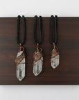Three clear quartz point necklaces for men – showing natural variation in size, shape, antique bronze copper wire wrapping.