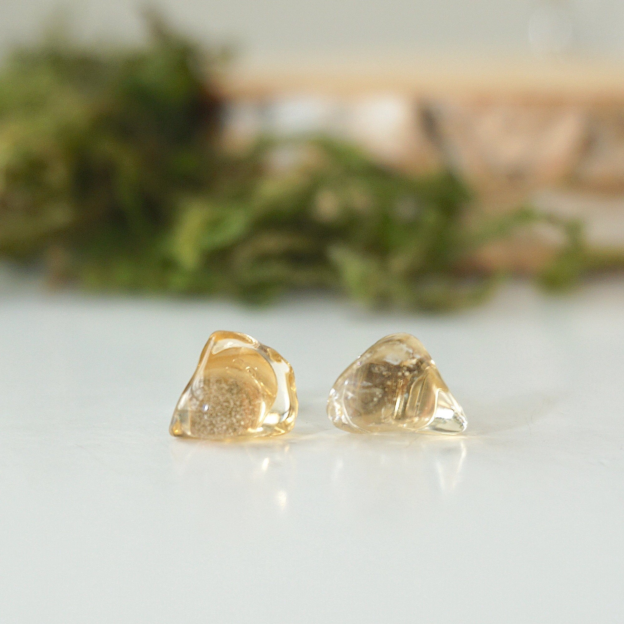 Close-up of raw unpolished citrine crystals on stud earrings showing natural golden color and organic texture
