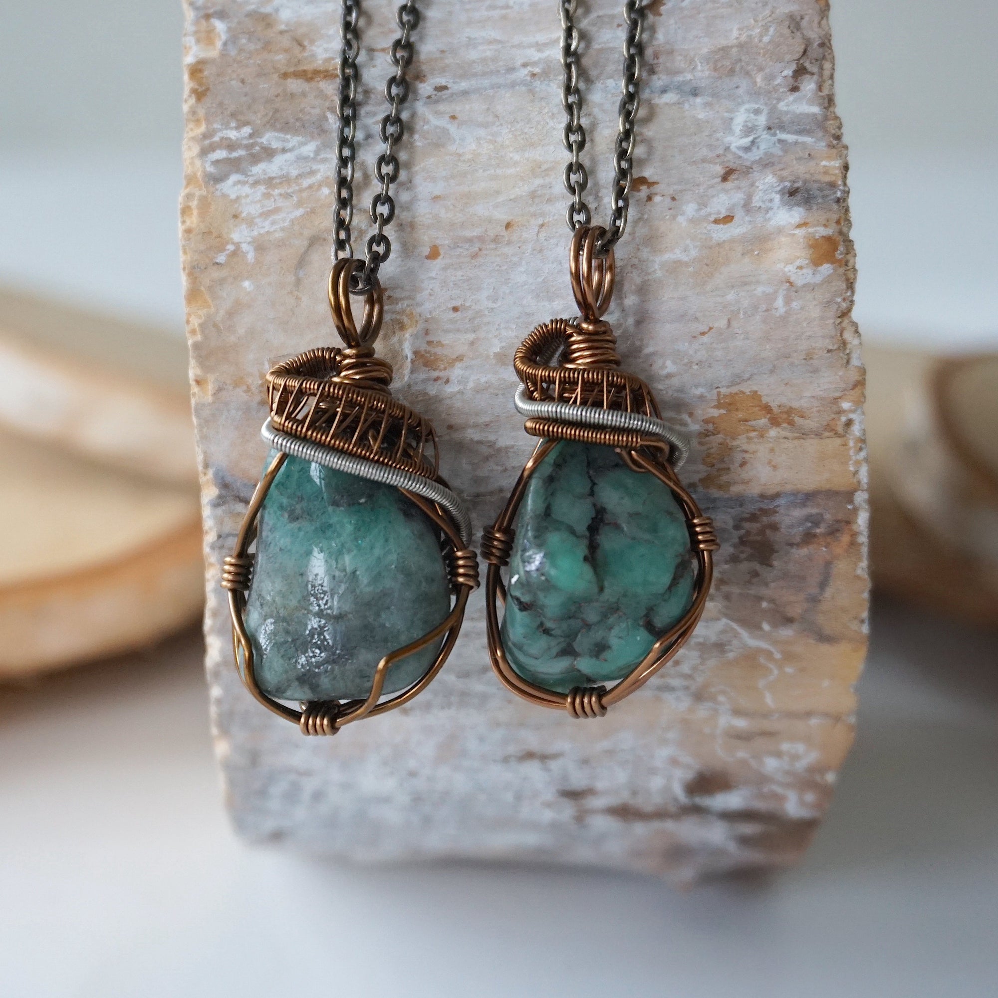 Two raw emerald pendants – displaying unique differences in natural emerald crystals, wire-wrapped for all genders.
