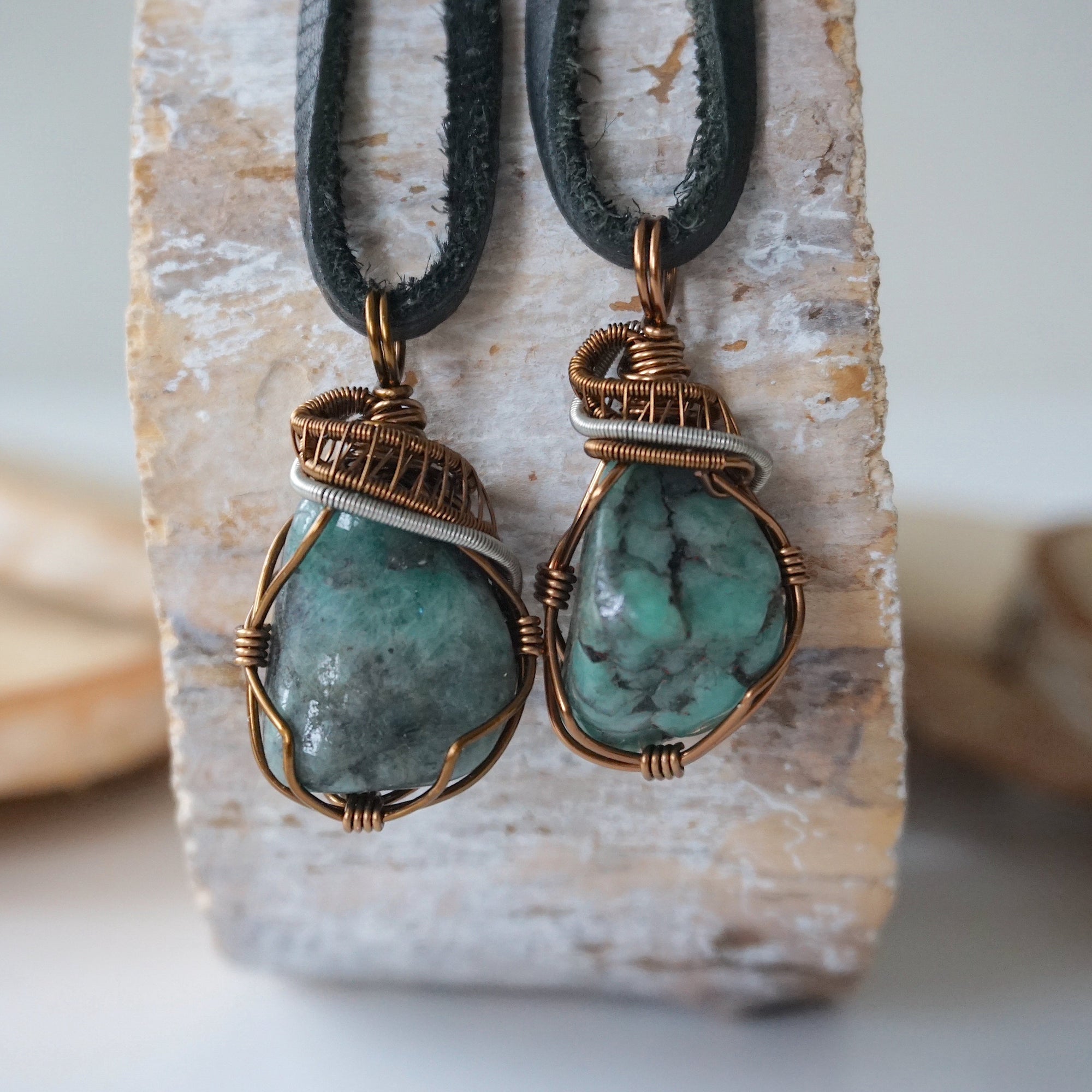 Two raw emerald pendants for men – unique differences in natural emerald crystals, wire-wrapped, black leather cord.