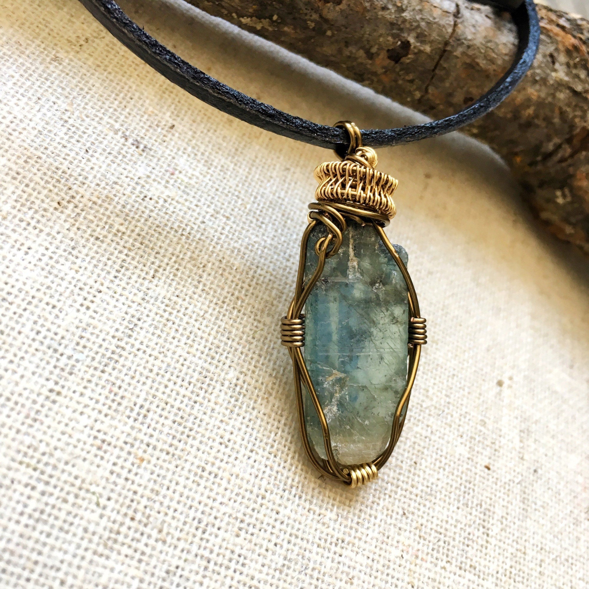 Right angle close-up of green kyanite necklace for men – detailed antique bronze and gold copper wire wrapping, natural raw green kyanite, masculine design.