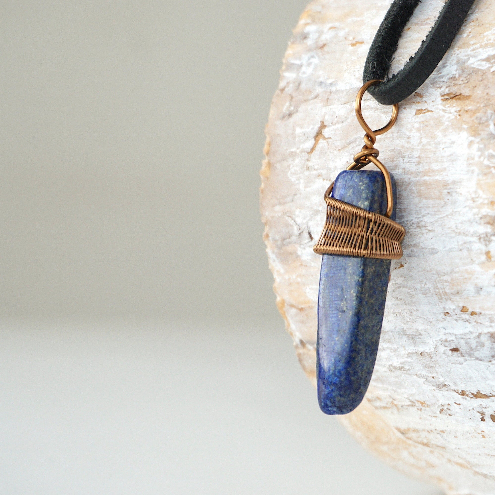 Left angle close-up of lapis lazuli point necklace for men – highlighting unique wire-wrapped artistry, blue lapis lazuli, antique bronze copper.