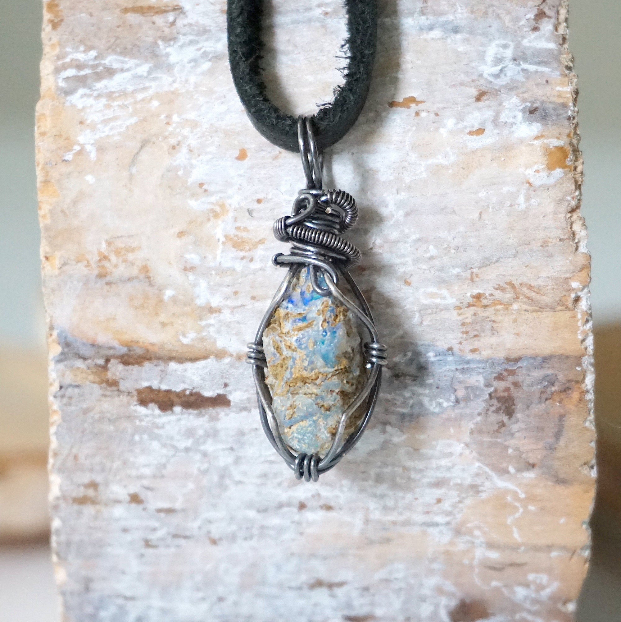 Back view of handcrafted men's opal necklace – natural stone and wire wrapping, October birthstone, black leather cord.