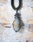 Back view of handcrafted men's opal necklace – natural stone and wire wrapping, October birthstone, black leather cord.
