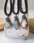 Three raw opal pendants for men – showing natural variation in size, shape, and color, handcrafted with antiqued sterling silver wire.