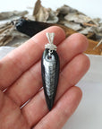 Orthoceras fossil pendant in hand for size reference – genuine black fossil, 925 sterling silver wire, ancient ocean jewelry, masculine design.
