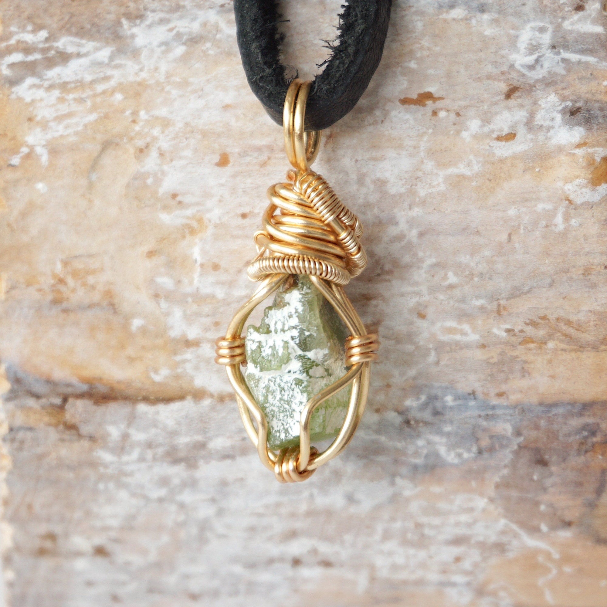 Back angle view of raw peridot necklace for men – showcases wire wrapping and natural stone matrix.