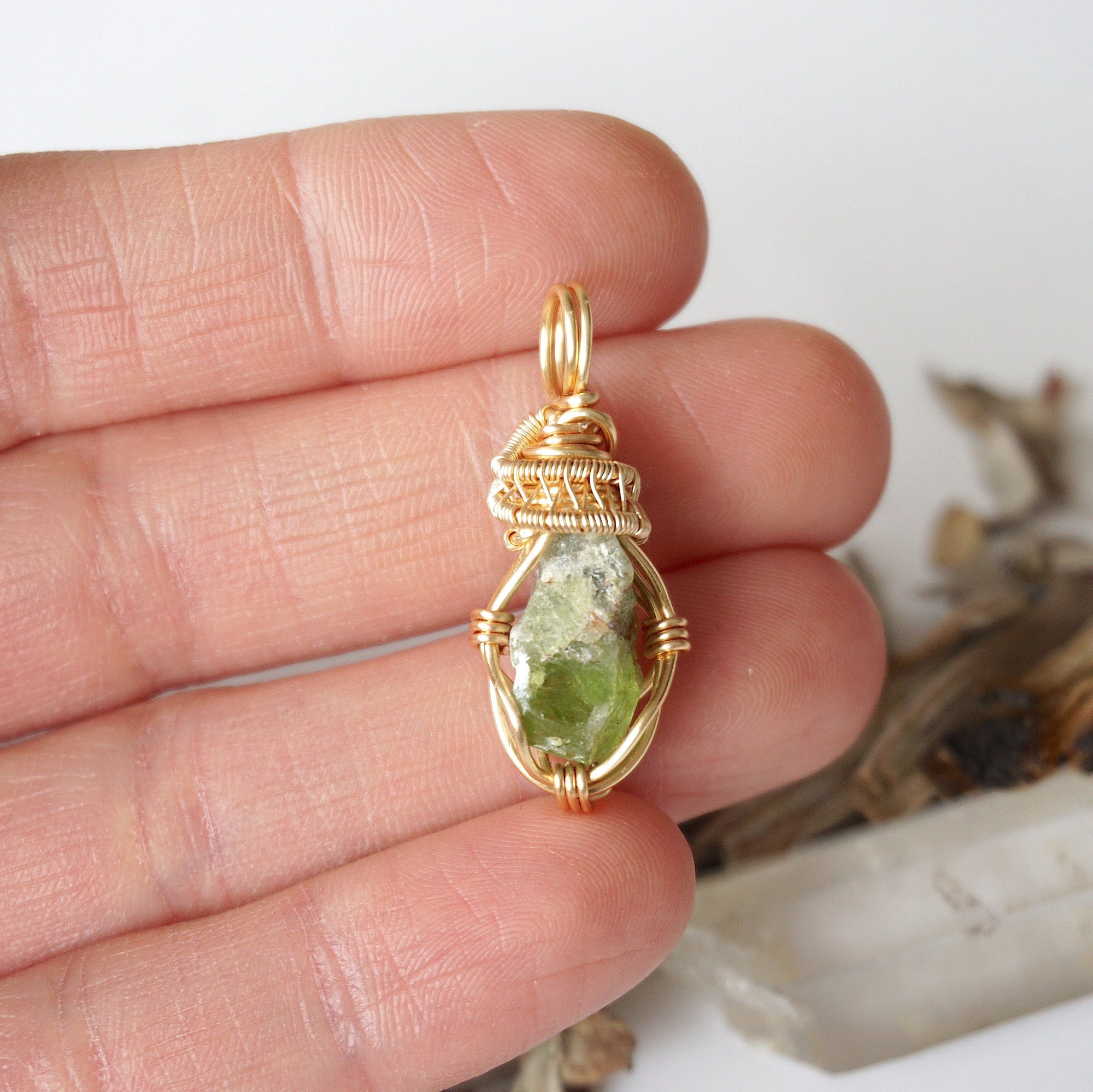 Raw peridot necklace for women in hand – size reference, showcases natural green peridot and gold copper wire wrapping.
