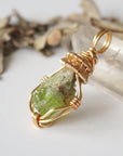 Left angle detail of raw peridot necklace for women – close-up of wire wrapping and vivid green peridot.