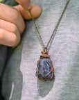 Sapphire necklace worn by male model – genuine raw sapphire pendant, bronze copper wire, unisex September birthstone jewelry.