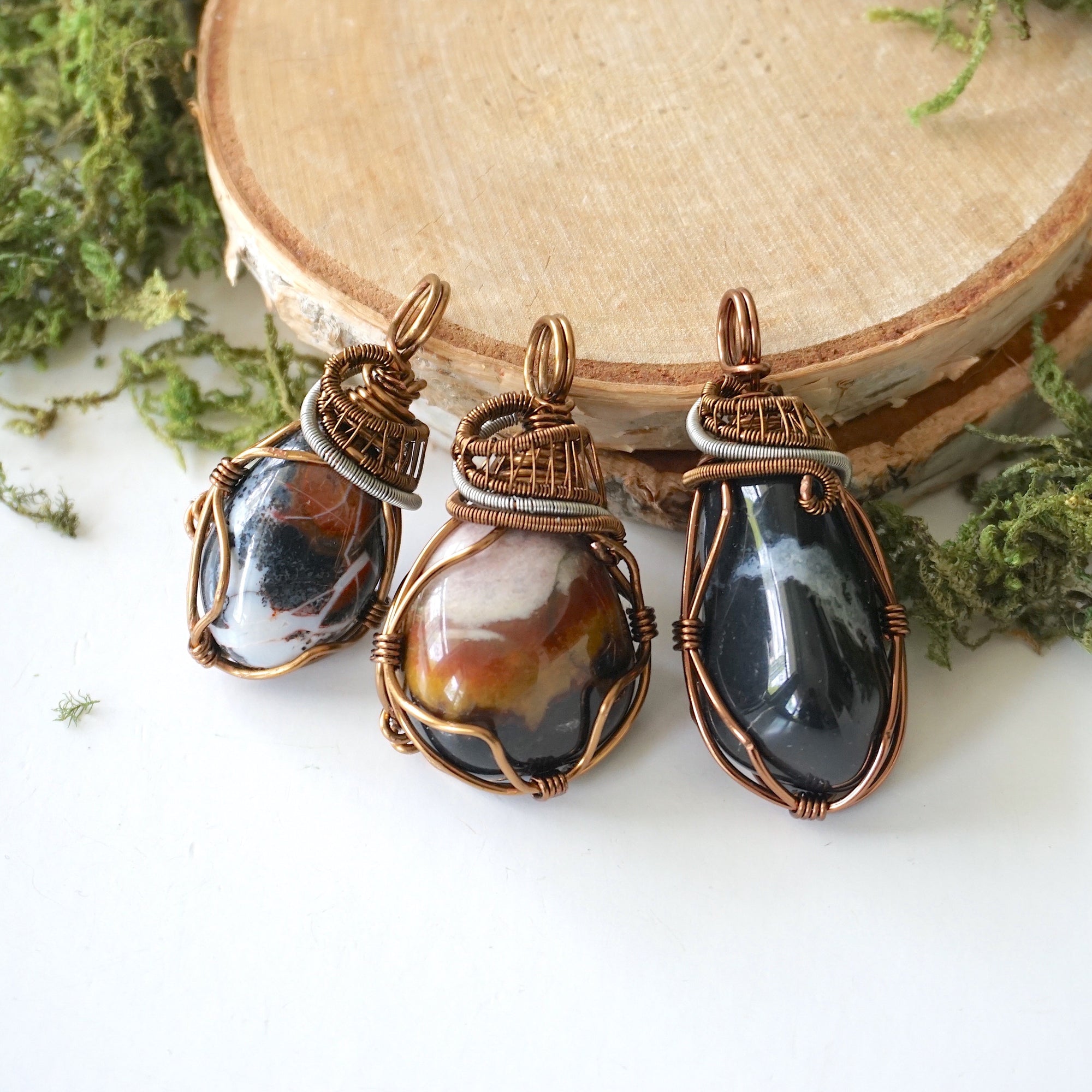 Three raw sardonyx pendants – showing natural variation in size, shape, and color pattern, handcrafted unisex birthstone jewelry.