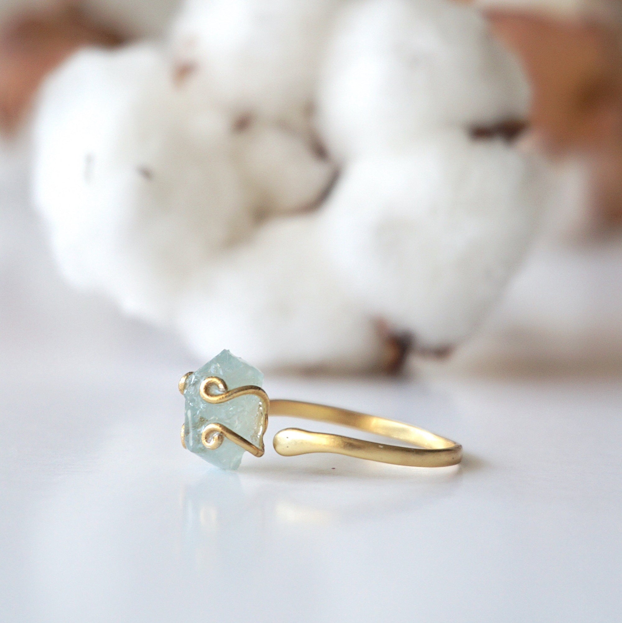 Left side angle of adjustable aquamarine ring, showing raw aquamarine and open band in 14k gold vermeil