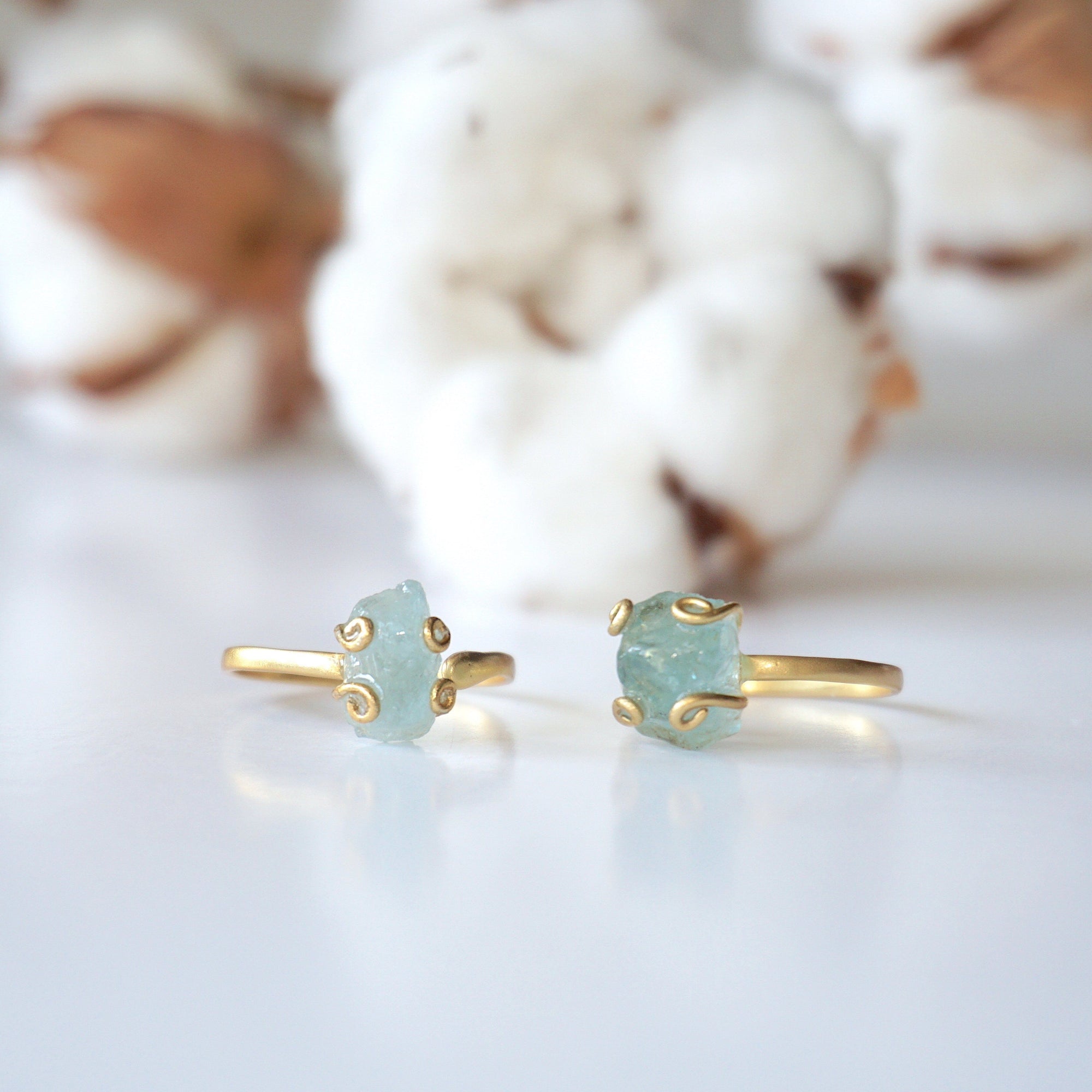 Two adjustable aquamarine rings side by side, showing natural variation in aquamarine's size, shape, and color, 14k gold vermeil