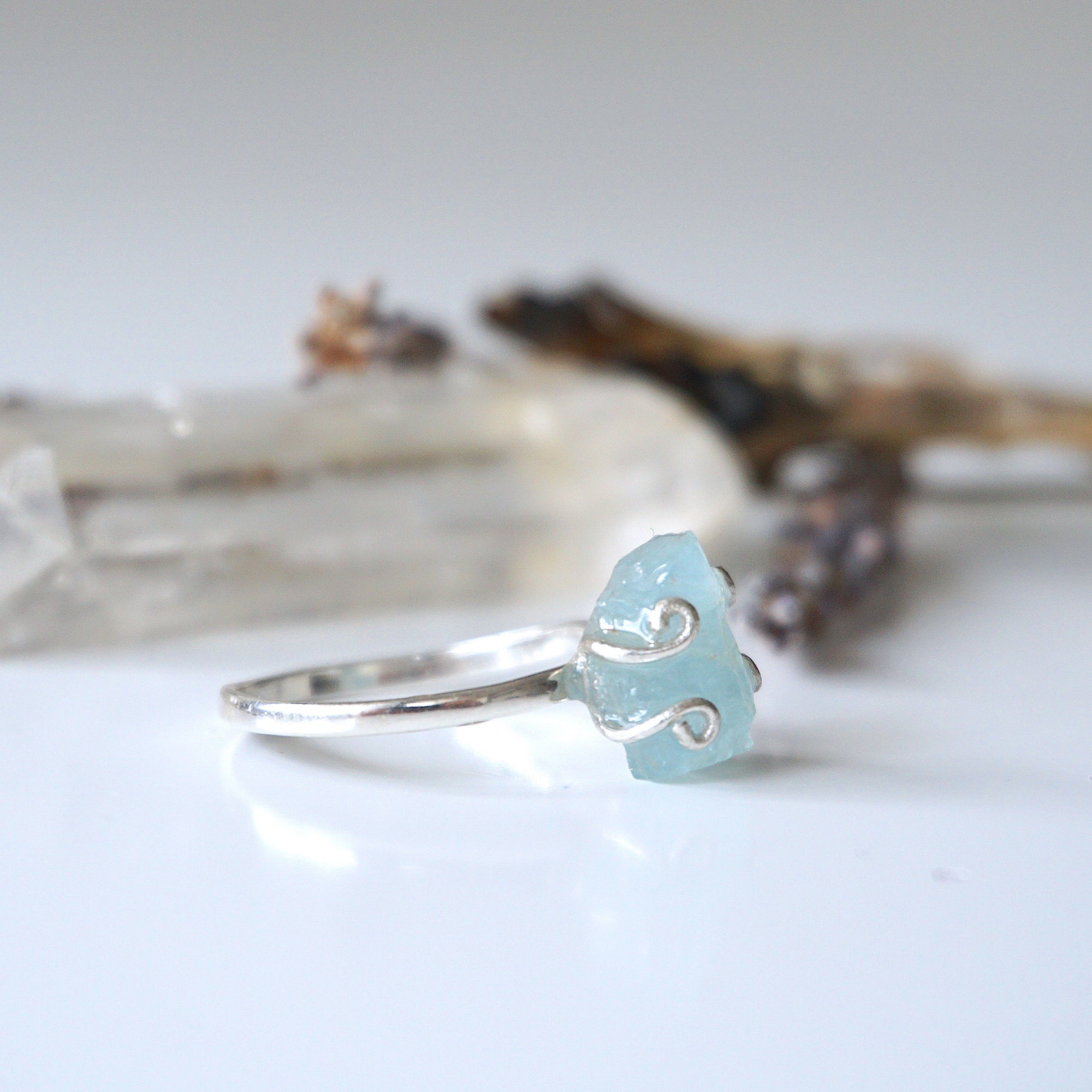 Right angle view of adjustable aquamarine ring, highlighting prong setting and raw gemstone, 925 sterling silver