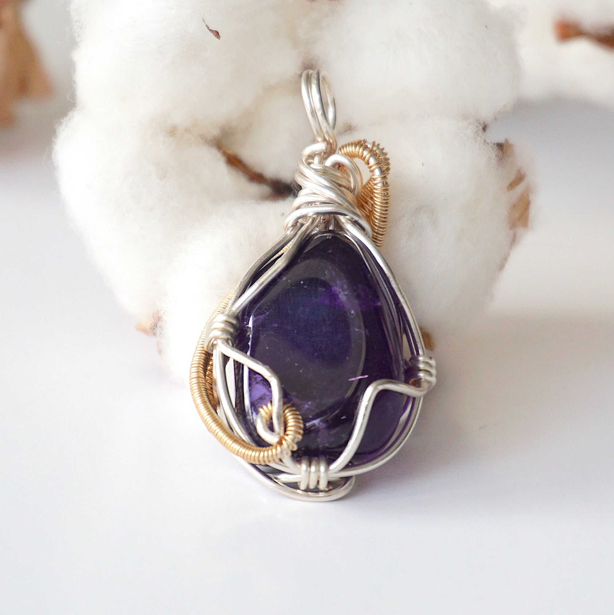 Back side angle of women’s amethyst pendant, polished dark amethyst, silver and gold plated copper artisan wire wrap