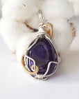 Back side angle of women’s amethyst pendant, polished dark amethyst, silver and gold plated copper artisan wire wrap