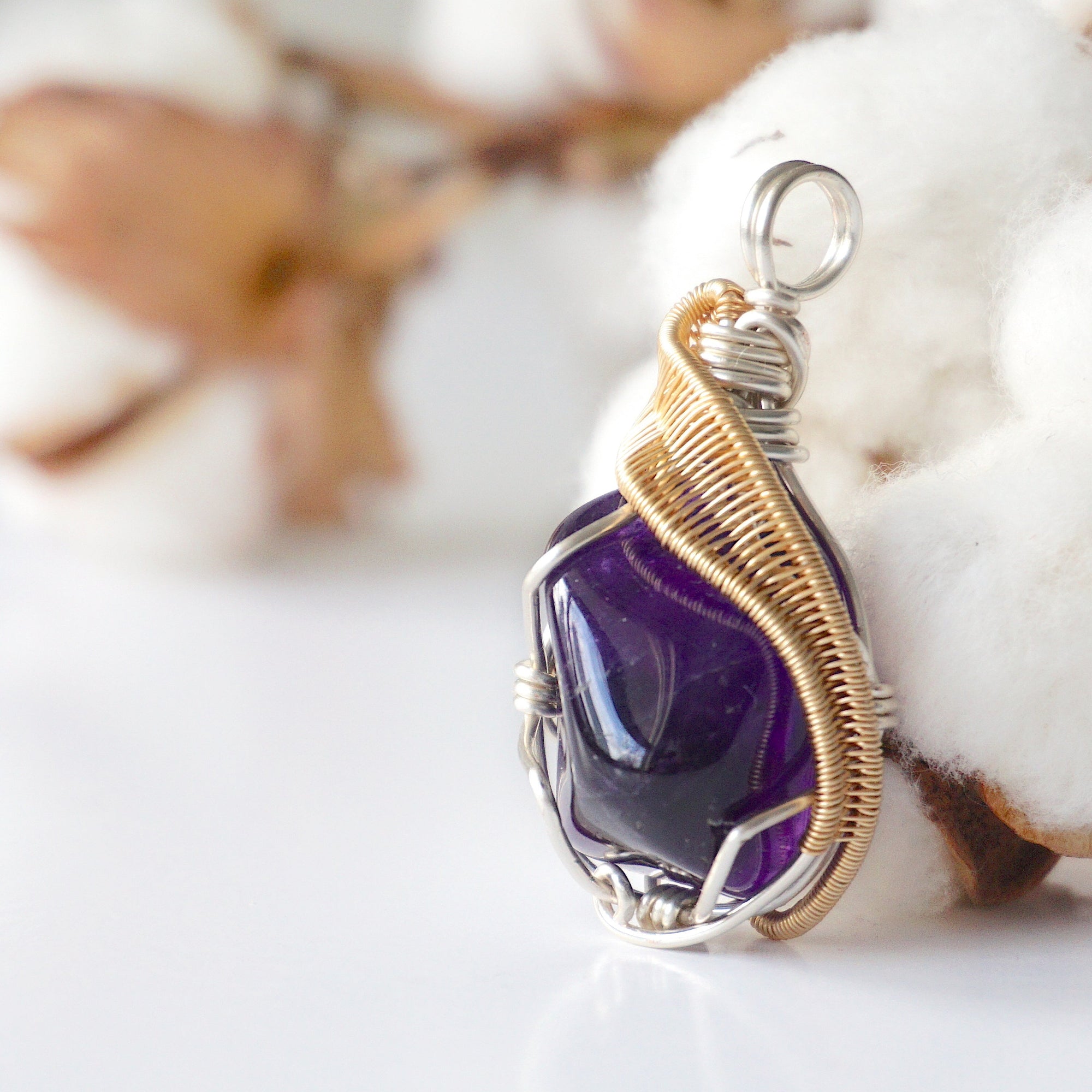 Left side angle of women’s amethyst necklace, polished dark amethyst pendant, silver and gold plated copper wire wrap