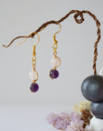 Front view of amethyst and rose quartz drop earrings with 6mm polished beads, gold plated copper wire wrapped dangle design