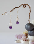 Zoomed out view of minimalist amethyst and rose quartz dangle earrings in silver plated copper with fish hook ear wires